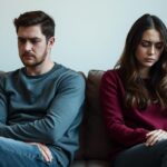 Para siedząca tyłem do siebie na kanapie - jeden z sygnałów, po czym poznać że związek się rozpada
