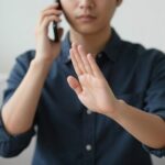 Osoba grzecznie odmawiająca zaproszenia podczas rozmowy telefonicznej, jak grzecznie odmówić zaproszenia